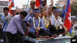 Anti-government protesters who had been in prison since their arrest in January, wave from atop a truck during a rally, in Phnom Penh, file photo. 