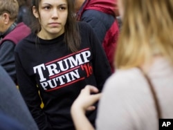 FILE - A woman wears a shirt reading "Trump Putin '16" while waiting for Republican presidential candidate Donald Trump to speak at a campaign event at Plymouth State University in Plymouth, New Hampshire, Feb. 7, 2016.