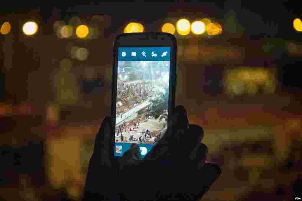 周日凌晨的香港金钟过街天桥上，抗议学生用手机录制视频 (美国之音方正拍摄)
