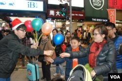 學民思潮召集人黃之鋒(左一)向途人派發聖誕氣球