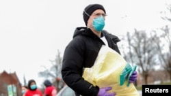 A volunteer with Project C.U.R.E. accepts personal protective equipment to be donated to healthcare workers treating coronavirus disease (COVID-19) in Chicago, IL. (File)