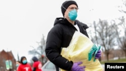 Seorang relawan menerima alat pelindung diri yang akan disumbangkan ke para petugas medis yang merawat pasien virus corona (COVID-19) di Chicago, Illinois. (Foto: Reuters)