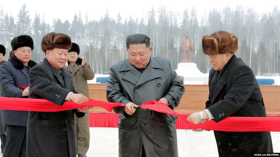 Pemimpin Korea Utara Kim Jong Un didampingi oleh Pak Pong Ju, wakil ketua Komisi Urusan Negara DPRK, memotong pita saat upacara di Kabupaten Samjiyon, Korea Utara, pada 2 Desmeber 2019. (Foto: KCNA via Reuters)