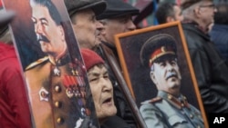 FILE - Russian communists carry portraits of former Soviet leader Joseph Stalin as they march along Kremlin Towers during a May Day rally in Moscow, May 1, 2015. The millennial generation of Americans is being criticized as being unaware of the historical ills of communism.