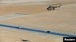 FILE - Afghan pilots train in a military helicopter to use new rockets, on the outskirts of Kabul, Afghanistan, December 2014.