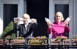 Residents exercise on their balconies according to the instructions of fitness trainer Patricio Cervantes during the spread of coronavirus disease (COVID-19) in Hamburg, Germany, March 26, 2020. (REUTERS/Fabian Bimmer)