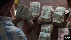 ရန်ကုန် အသီးအနှံဈေးတခုမှာ ဈေးဝယ်ဖို့ မြန်မာကျပ်ငွေ ရေတွက်နေသူတဦး။ (ဧပြီ ၁၉၊ ၂၀၁၇)