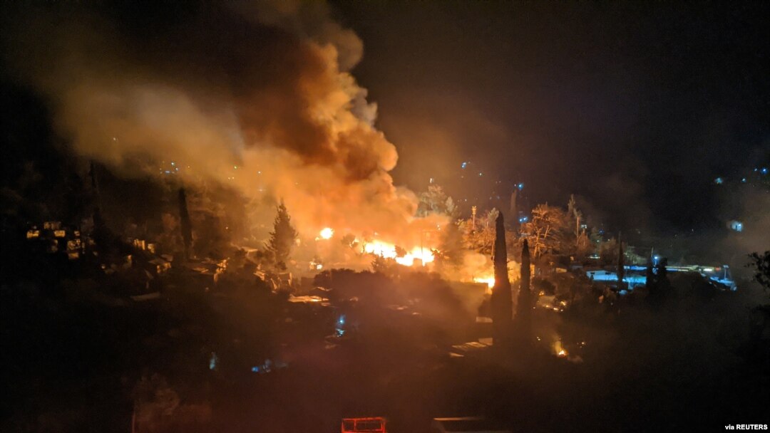 FILE - A fire burns at the migrant camp on the island of Samos, Greece, April 26, 2020.
