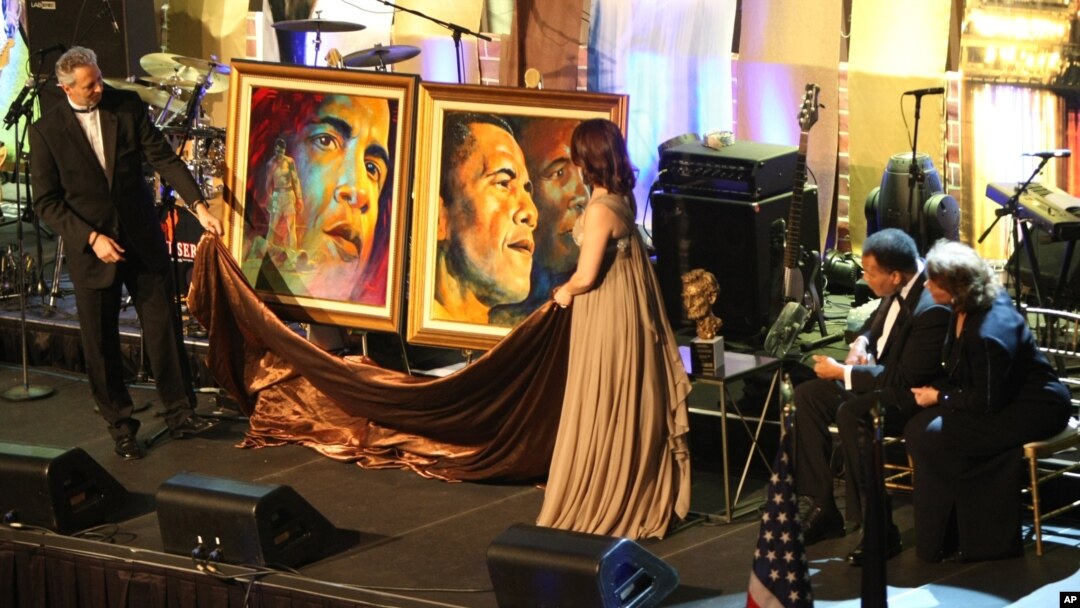 FILE - Muhammad Ali , accompanied by his wife Lonnie Ali, right , receives two portraits of President-elect Barack Obama during an evening on the eve of his inauguration, on Monday, January 19, 2009 in Washington.