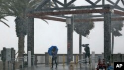 Los amantes de la playa fueron sorprendidos por lluvias torrenciales asociadas con la tormenta tropical Colin en Clearwater Beach, Florida, el lunes, 6 de junio de 2016.