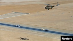 FILE - Afghan pilots train in a military helicopter to use new rockets, on the outskirts of Kabul, Afghanistan, December 2014.