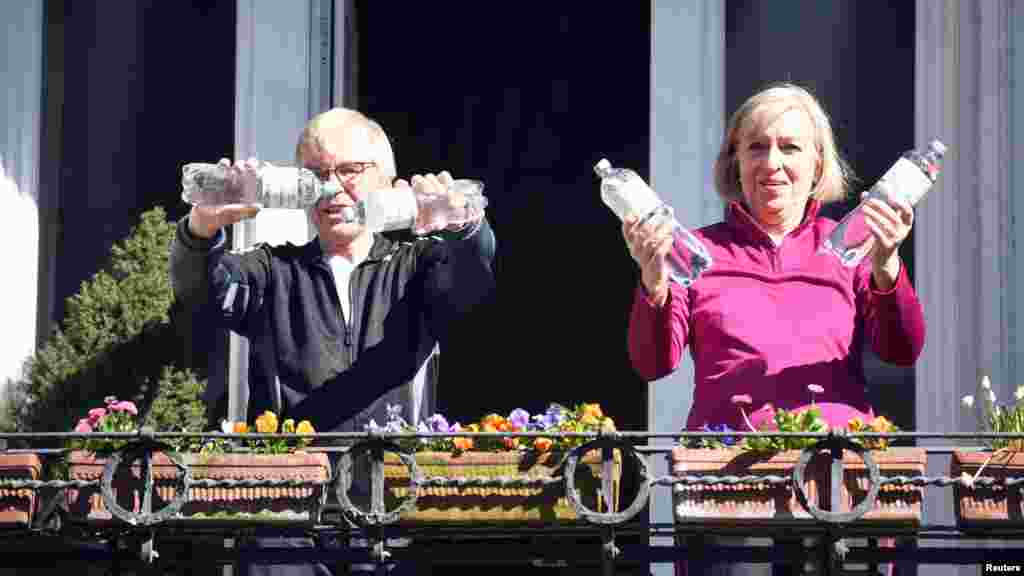 Una pareja se ejercita con unas botellas de agua mientras siguen las indicaciones de un entrenador en un complejo de edificios de Hamburgo, Alemania. Para las personas de la tercera edad, más vulnerables al coronavirus, es importante que mantengan un estilo de vida sana como medida para minimizar sus posibilidades de contagio.