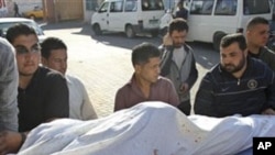 Palestinians wheel one of four dead bodies following an Israeli strike at a house east of Gaza City, to the morgue of Shifa hospital in Gaza City, Tuesday, March 22, 2011