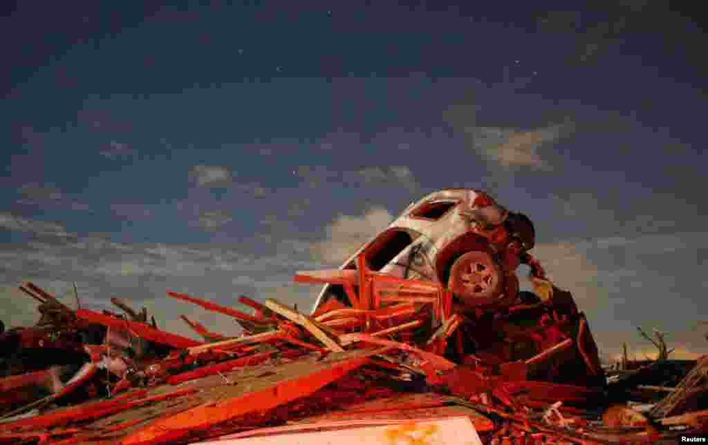 A vehicle sits on a pile of debris from the destruction caused by a tornado that touched down in Washington, Illinois, USA, Nov. 17, 2013.