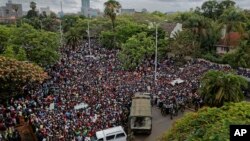 Une foule de milliers de manifestants demandant la démission du président Robert Mugabe se réunit derrière un cordon de l'armée sur la route menant à State House à Harare, Zimbabwe, 18 novembre 2017.