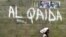 A girl walks past a wall with graffiti about the al-Qaida network in a Muslim area of the northern city of Kano, Nigeria, (File photo).