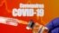 FILE PHOTO: A small bottle labeled with a "Vaccine" sticker is held near a medical syringe in front of displayed "Coronavirus COVID-19" words in this illustration taken April 10, 2020.