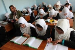 Pada bulan pertama tahun ajaran, siswi kelas 12 mengangkat tangan untuk menjawab pertanyaan yang diajukan oleh seorang guru di SMA di Khairkhana, Kabul. (Foto: UNAMA)