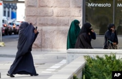 FILE - Female members of Minnesota's Somali community cover their faces as they arrive on April 23, 2015, for a hearing in federal court in St. Paul, Minnesota, in the case of several Minnesotans accused of plotting to travel to Syria to join the Islamic State group.