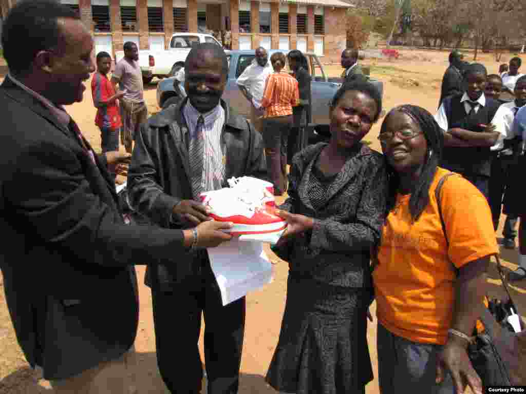 Noah Manyika with some school authorities in one of the shoe distribution events.