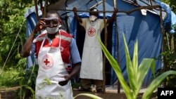 Agents de santé près du point de contrôle à la frontière de Mpondwe entre l'Ouganda et la République démocratique du Congo, le 14 juin 2019.