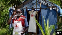 Les agents de santé à un point de passage non annoncé au journal officiel dans le village de Mirami, près du point de contrôle à la frontière de Mpondwe entre l'Ouganda et la République démocratique du Congo, le 14 juin 2019.