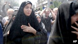 FILE - Iranians attend the funeral of victims of an Islamic State militant attack in Tehran, Iran, June 9, 2017.