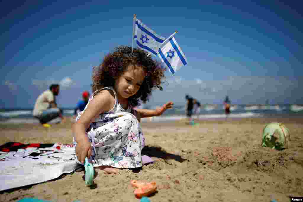 دختری در روز استقلال اسرائیل، هفتاد و یکمین سالگرد بنیانگذاری این کشور، در ساحل تل آویو بازی می کند.