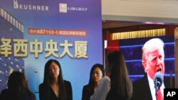 A projector screen shows a footage of U.S. President Donald Trump as workers wait for investors at a reception desk during an event promoting EB-5 investment in a Kushner Companies development at a hotel in Shanghai, China, May 7, 2017. 