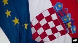 A Croatian, right, and a EU flag fly in downtown in Zagreb, Croatia, Sunday, Jun. 30, 2013.