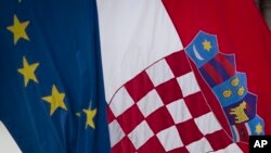 A Croatian, right, and a EU flag fly in downtown in Zagreb, Croatia, Sunday, Jun. 30, 2013.