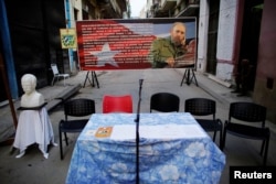 FILE - A bust of Cuban independence hero Jose Marti (L) and an image of late Cuban president Fidel Castro is seen on a street ahead of the nominations for candidates for municipal assemblies in Havana, Cuba, Sept. 4, 2017.