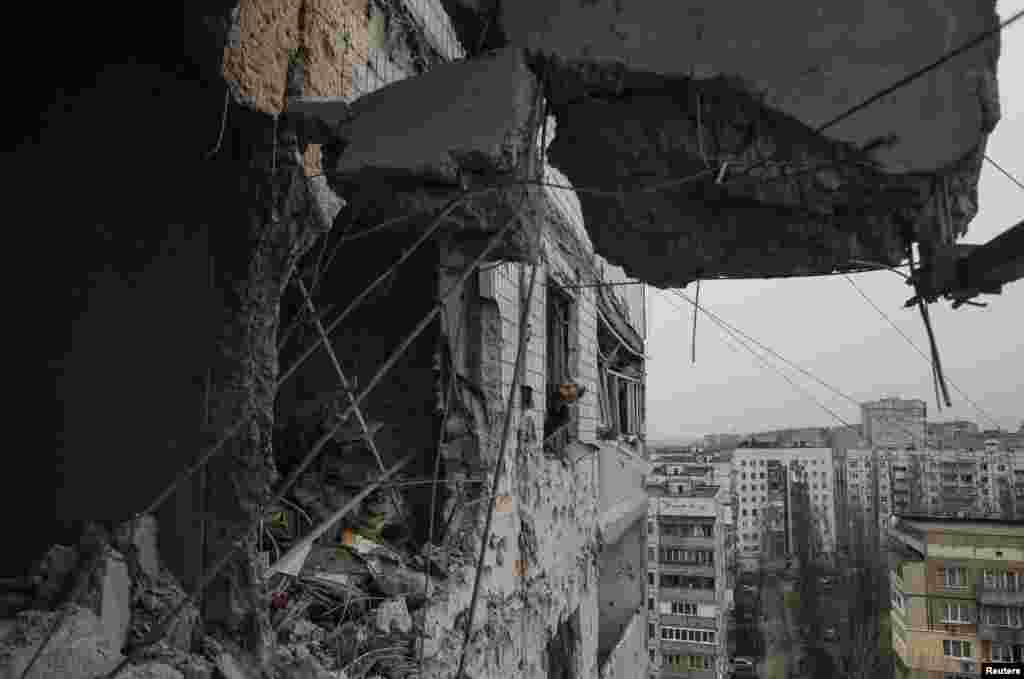 A municipal official looks through the window of a residential block, which was damaged by shelling, according to locals, in Donetsk, Ukraine. &nbsp;