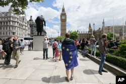 A demonstrator wrapped in the EU flag takes part in a protest opposing Britain's exit from the European Union in Parliament Square following yesterday's EU referendum result, London, Saturday, June 25, 2016.