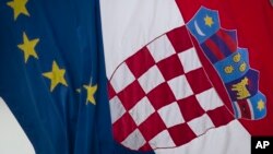 A Croatian, right, and a EU flag fly in downtown in Zagreb, Croatia, Jun. 30, 2013.