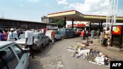 Mituka na bakumbi na yango basali molongo mpo na kozela essence na satation service na Kinshasa, 15 mai 2000.