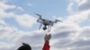 FILE - In this April 29, 2018, file photo, a drone operator helps to retrieve a drone after photographing over Hart Island in New York.