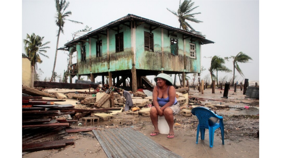 A woman sits near her house damaged the passing of Hurricane Iota, in Puerto Cabezas, Nov. 18, 2020.