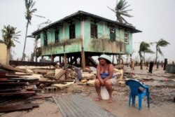 A woman sits near her house damaged the passing of Hurricane Iota, in Puerto Cabezas, Nov. 18, 2020.