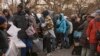 ARCHIVO - Migrantes toman mantas cerca de un Centro de Ayuda a Migrantes en la escuela primaria St. Brigid, el martes 5 de diciembre de 2023, en Nueva York.