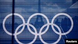 The Eiffel Tower is seen through a net with a part of the logo of the Paris 2024 Olympic and Paralympic Games from the Trocadero square in Paris.