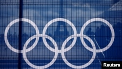 The Eiffel Tower is seen through a net with a part of the logo of the Paris 2024 Olympic and Paralympic Games from the Trocadero square in Paris