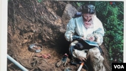 Antropóloga forense de la Unidad de Búsqueda toma una dentadura postiza encontrada en selvas y bosques donde se ocultaron cuerpos de personas desaparecidas. Esta imagen de 2022 es parte de la exhibición presentada en el Instituto de la Paz de EEUU.