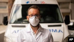 Doctor Sebastian Yancev stands in front of the ambulance used to move some patients to hospitals in Montevideo, Uruguay, from an Australian cruise ship stricken with a coronavirus outbreak.