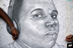 Protesters autograph a sketch of Michael Brown during a protest on August 18, 2014, in Atlanta, Georgia.