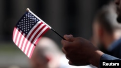 Tư liệu: Một ứng viên mang theo lá cờ Mỹ tại Lễ Nhập tịch do Sở Di trú và Nhập tịch Hoa Kỳ cử hành tại Rockefeller Plaza ở New York ngày 17/9/2019. REUTERS/Shannon Stapleton