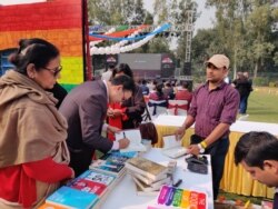 Author and lawyer Saif Mahmood signs his book "Beloved Delhi" at the queer literature festival. (Anjana Pasricha/VOA)