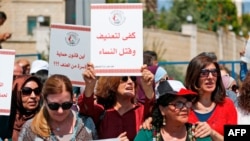 Palestinian women protest in support of women’s rights outside the prime minister’s office in the West Bank city of Ramallah on September 2, 2019, after a young Palestinian died in a case that has raised emotions. Arabic slogans on placards call for…