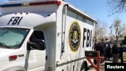 Law enforcement personnel including FBI agents are seen March 13, 2018, near a home that was hit with a parcel bomb in Austin, Texas. 