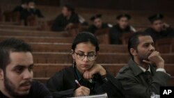 FILE - Mahinour el-Masry, an Egyptian activist, takes notes during a trial session of activists facing charges on organizing unauthorized protests, at a courtroom in Cairo, Egypt, Dec. 4, 2014.